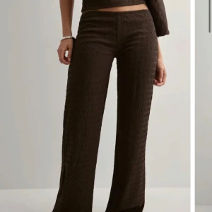 Bruna vida byxor i strukturerat tyg - Säljer ett par bruna byxor från Nelly!!💕säljer då dom är lite för långa för mig!!