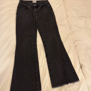 Low waist bootcut jeans från Abrand - Snygga svarta jeans från Abrand med bootcut passform och frans kanter nertill. Dom är low waist 