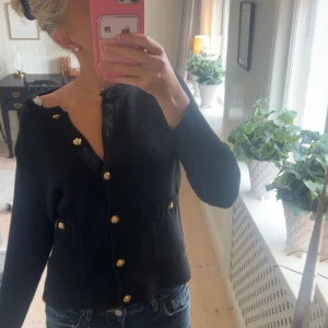 Svart stickad kofta från Zara med guldknappar - Svart stickad kofta från Zara med guldiga knappar. Använd endast ett fåtal gånger så inga defekter😇
