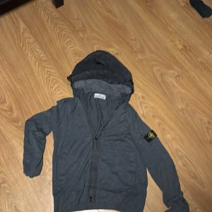 Stone Island tunn tyg jacka - Snygg grå jacka från Stone Island. Perfekt inför hösten då den har ett tunnare material, storlek S sitter true to size, certilogo med qr kod finns som äktehetsbevis.
