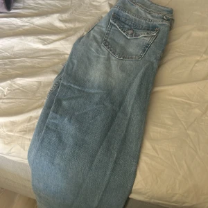 Ljusblå jeans från Gina Tricot - Säljer ett par ljusblå jeans från Gina Tricot i storlek 152. Jeansen har klassisk femficksdesign, raka ben och knäppning med knappar framtill. Perfekta för en chill och avslappnad stil.