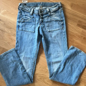 Lee jeans med fina detaljer  - Från Lee. Midjemått 41 cm innerbenslängd 86 cm. Fint skick! Modell ”bootcut leg”