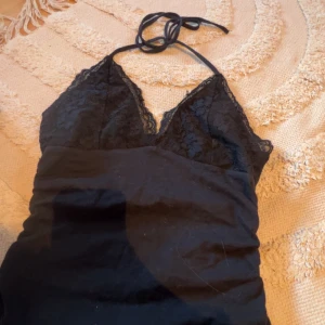 Svart spetstopp med halterneck - Svart linne med spetsdetalij och knyt band