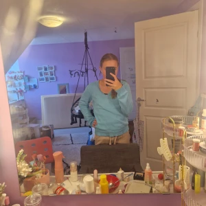 Ljusblå stickad tröja från Gant - Säljer en ljusblå stickad tröja från Gant med v-ringning och broderad logga på bröstet. Tröjan har ribbade muddar vid ärmslut och nederkant samt lång ärm. Perfekt för dig som gillar klassisk och clean stil. Är aldrig använd. Storlek L men funkar som  M