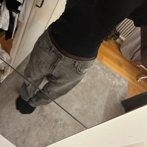 Grå baggy jeans från Bershka - Säljer ett par gråa baggy jeans från Bershka i storlek 40. De har en loose fit med raka ben och klassisk femficksdesign. Jeansen är tillverkade i bomull och har en snygg tvättad look som passar perfekt till streetwear-stilen.
