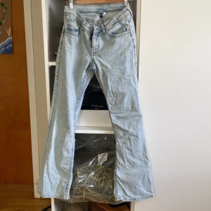 Ljusblå bootcut jeans från Divided - Säljer ett par ljusblå bootcut jeans från Divided i storlek 40 men känns som 38. Jeansen har klassisk femficksdesign, snygga broderade detaljer på bakfickorna och är tillverkade i mjukt bomullsjeans. Perfekta för dig som gillar retrovibbar och bredare ben.