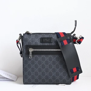 Gucci väska- Köp görs via insta: masionla_drippo - Snygg axelväska från Gucci i mörkgrått med klassiskt GG-monogram. Väskan har en bred axelrem i marinblått och rött, silverfärgad dragkedja framtill och detaljer i svart skinn. Perfekt för dig som vill ha en stilren och lyxig accessoar. Köp görs via Masion la drippo