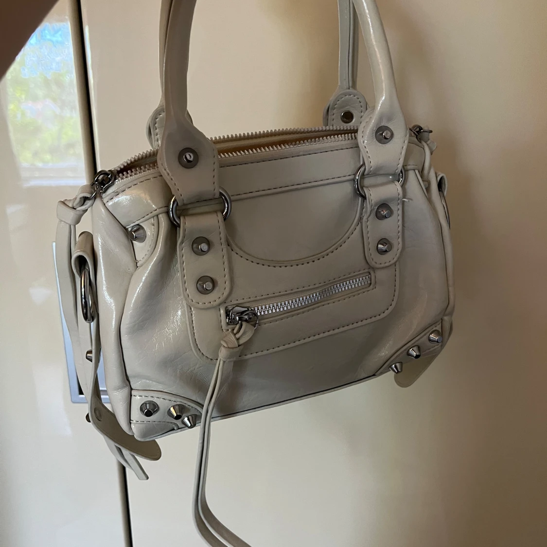 Beige handväska med nitar och dragkedja