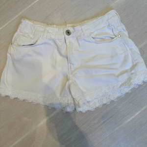 Vita shorts med spetskant - Snygga vita ZARA jeansshorts med blomdetaljer längs kanten. 