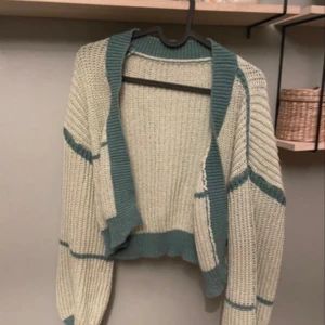 Grön stickad kofta - Säljer en  stickad kofta i grön. ånga ärmar med gröna ränder. Använd en gång