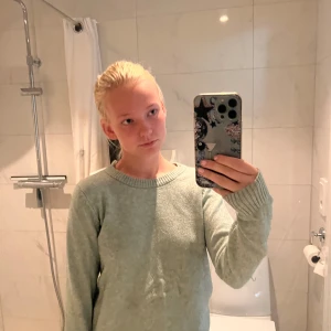 Ljusgrön stickad tröja från VILA - Mysig ljusgrön stickad tröja från VILA med rund halsringning och ribbade muddar. Perfekt för lager-på-lager och chill dagar. Enkel och stilren design som funkar till allt. Långärmad och i mjukt material.