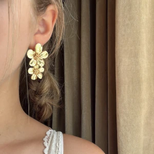 Rost fria Guldiga blommiga örhängen⭐️ - Stora statement-örhängen i guld med detaljerade blommor i två nivåer. Blommorna har en snygg struktur och ger en riktigt cool och unik look. Perfekta för dig som vill sticka ut och addera lite extra till din outfit.✨🩷😆