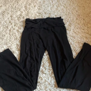 Svarta mjukisbyxor med låg midja - Svarta mjukisbyxor med bred, vikt midja och raka ben. Sköna och stretchiga, perfekta för chill eller träning. Mjukt material som känns bekvämt hela dagen.