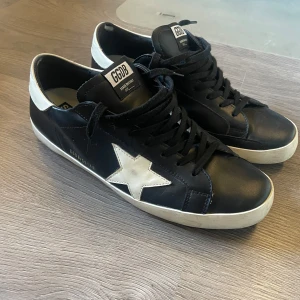 Golden Goose svarta - Tvär feta Golden Goose som är använda med ändå okej skick. Det ända är defekten på bild fem men det kan man limma om man vill. Dom är storlek 46. 