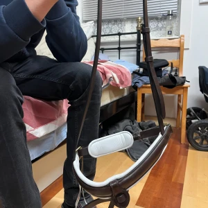 Brunt och vitt anatomiskt nosgrimma - Säljer en snygg anatomiskt formad nosgrimma i brunt skinn med vit vaddering. Nosgrimman har stilrena detaljer och mässingsfärgade spännen. 