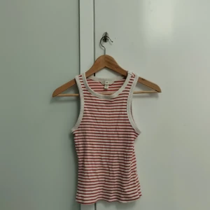 Rödvitt randigt linne från H&M  - Säljer detta rödvitrandiga linne från H&M i storlek XS, är ribbstickat med stretch i. Har lite fläckar vid armarna men inget man tänker på! Säljer då det inte kommer till användning och blivit för litet, köparen står för frakt och pris kan diskuteras!💕