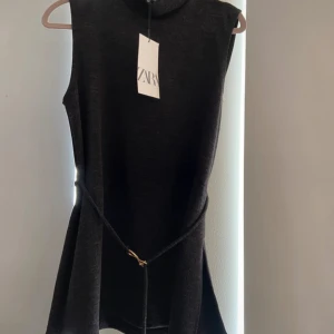 Svart ärmlös topp från Zara💕 - Stilren svart topp från Zara med hög hals och markerad midja med ett smalt bälte och gulddetalj Storlek S💕 Lappen är även kvar.