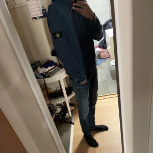 Blå stone Island hoddie  - Blå fräsch stone Island hoddie med den klassiska loggan på armen. Perfekt till nästan alla jeans. Funkar också fint på alla årstider. Jag är runt 180 och väger 64 och den sitter jätte bra.