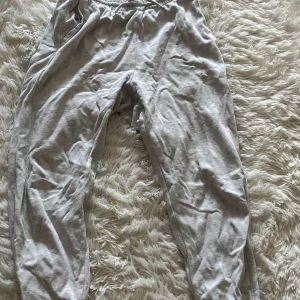 Grå mjukisbyxor med resårmidja - Lätta och sköna grå mjukisbyxor med resår i midjan och avslappnad passform. Perfekta för chill dagar hemma eller när du vill vara bekväm. Gjorda i mjukt bomullsmaterial.