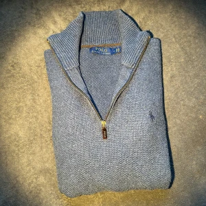 Blå stickad half zip från Polo Ralph Lauren - Säljer denna asfeta blåa stickade tröja från Polo Ralph Lauren med half zip och hög krage. Cond 8/10 prima skick förutom lite nopprighet på armarna. Storlek M, hör av er vid frågor! Mvh
