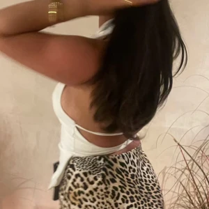 Vit halterneck korsett med dragkedja - Säljer en vit korsett-topp med halterneck och djup v-ringning. Toppen har krage, öppen rygg med smala band och dragkedja framtill. Figurnära passform och lätt utsvängd nertill. Perfekt för dig som vill sticka ut med en trendig look. Använt 2 gånger, i bra skick. 