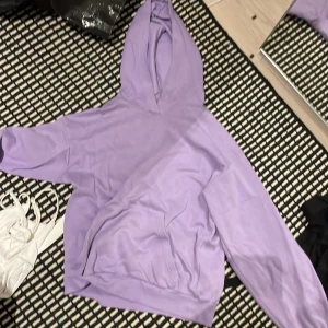 Ljuslila hoodie från H&M - Säljer en ljuslila hoodie från H&M i storlek 170. Tröjan har huva, magficka och ribbade muddar vid ärmsluten. Perfekt för dig som gillar en chill och enkel stil. Materialet är mjukt och skönt, troligtvis bomullsmix.