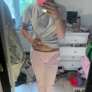 Ljusrosa Juicy Couture mjukisbyxor XXS - Säljer ett par ljusrosa mjukisbyxor från Juicy Couture i storlek XXS. Byxorna har raka ben, låg midja och glittrig Juicy-text baktill. Mjukt material och klassisk Y2K-vibe, perfekta för en chill och trendig look. Den har också en fläck på höger ben, så jag råder dig till att vara lite kortare o sen sy upp dom, men annars så funkar dom ju ändå. Jag har också sytt in dom, jag är en 15åring tjej och är 158 cm lång, dom sitter perfekt på mig i midjan men dom är aldelds för långa. 