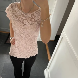 Rosa spetstopp - Rosa kortärmad tröja i spets från Orsay i fint skick. Kan inte hitta storlek men skulle säga S, passar även M. Fastsytt tyg på insidan. Använd gärna köp nu!