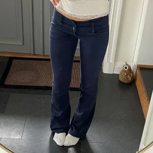 Mörkblå lågmidjade bootcut jeans - Mörkblå lågmidjade jeans som jag har sytt till bootcut från Oxxy i storlek 36. Tvärs över midjan är det 38 cm + stretch och innerbenslängden är 81 cm. Passar mig bra på längden och jag är 172. Använd gärna köp nu!