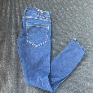 Blå jeans från Dondup - Snygga blå jeans från Dondupp med klassisk femficksdesign och kontrastsömmar. Jeansen har normal passform och raka ben, tillverkade i mjukt denimtyg. Perfekta för dig som gillar en enkel och stilren look. Säljer pågrund av att det blev fel med storleken. Dem är väldigt små. Skulle säga storlek XS! Hör av er om ni vill ha måtten 🤩