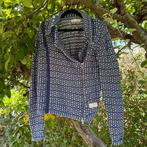 Blå stickad cardigan jacka Odd Molly - Säljer en blå stickad cardigan kofta från Odd Molly med vitt mönster och dragkedja framtill. Koftan  har lång ärm, krage och snygg broderad fjäril på insidan. Perfekt för dig som gillar unika detaljer och skön passform. Storlek 3 som enligt deras storleksguide motsvarar en storlek L. Fint skick, men den är något blekare än ny och kan ha tecken på användning. 