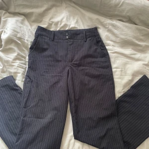 Svarta kostymbyxor med ränder Madlady - Snygga svarta kostymbyxor från Madlady med tunna vita ränder. Klassisk rak passform, midwaist. Storlek 34 och längd regular.🤍