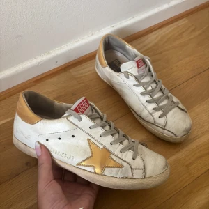 Golden Goose superstars i guld - Golden Goose superstars i vitt och guld. Skorna är i gott skick och är i storlek 37 (endast skor medföljer i köpet)