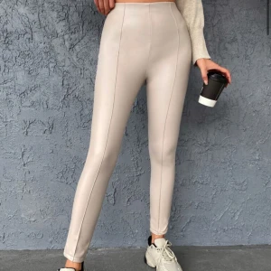 Beige höga leggings i skinnimitation - Snygga beige leggings med hög midja och tight passform. Byxorna har en stilren look med sömmar framtill. Den är endast använd en gång och är i topp skick! Skriv för fler bilder🥰
