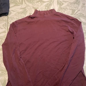 Vinröd polotröja från Y-3 - Säljer en vinröd polotröja från Y-3, designad av Yohji Yamamoto i samarbete med Adidas. Tröjan har en hög krage med Y-3-logga och är tillverkad i mjuk bomull. Perfekt för dig som gillar minimalistisk och stilren streetwear. Använd endast ett par gånger
