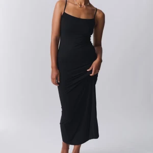 Svart långklänning med smala axelband - Snygg svart långklänning med smala axelband från Gina tricot.Den är vädligt enkel och stilren. Endast använd fåtal gånger. Säljer för att den inte kommer till anledning.