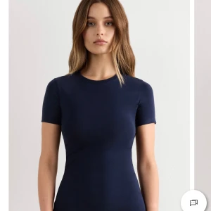 Mörkblå slim t-shirt i bomull - Snygg mörkblå t-shirt med rund hals och korta ärmar. Modellen är slim och sitter tajt mot kroppen, perfekt för dig som gillar en enkel och stilren look. Tillverkad i mjuk bomull som känns skön mot huden. Passar dig som vill ha en klassisk och clean vibe.