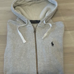Grå Ralph lauren zip hoodie - En grå Ralph lauren zip hoodie | väldigt bra skick utan några defekter | skick 9/10 | Storlek S | nypris 2000kr | kom gärna med bud om ni inte är nöjda med fasta priset | hör gärna av er vid minsta fundering 🤩🙌