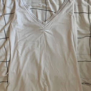 Vit linne med strass  - Snyggt linne med strass! Använd och tvättad fåtal gånger. Strass som har gått av under tiden💞bara ett fåtal! Storlek L men sitter som S/M💗