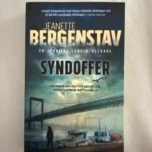 Syndoffer - En spännande Jennifer Sundin-deckare med oväntade vändningar och en mörk, suggestiv stämning. Perfekt för dig som gillar nervkittlande mysterier och cliffhangers. Omslaget visar en bro, båtar och en ensam person vid vattnet – redo för en ny gåta?