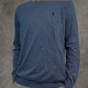 Slim tröja Polo Ralph Lauren - Snygg marinblå långärmad tröja från Polo Ralph Lauren i slim fit. Tillverkad i mjuk pima bomull och prydd med den klassiska broderade loggan på bröstet. Perfekt för dig som gillar stilrena och bekväma plagg med premiumkänsla.