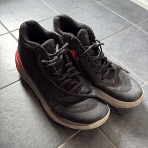 Puma MB.01 Melo sneakers svart/röd - Säljer ett par Puma MB.01 Melo sneakers i svart med röda detaljer och cool grafik på hälen. Skorna har snörning, rund tå och platt sula. Ovandelen är i textil och syntet, sulan är röd med Melo-logga och broderad detalj. Perfekta för dig som gillar basketstil.