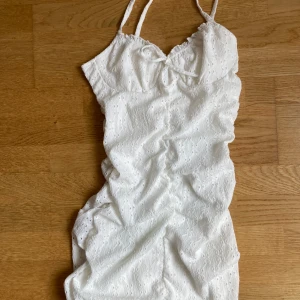Vit kort klänning med spetsdetaljer - Supersöt vit klänning med tunna axelband och broderade detaljer. Endast använd två gånger