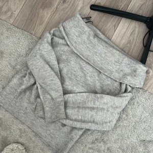 Beige offshoulder stickad tröja - Supermjuk beige stickad tröja med bred ribbad offshoulder-krage. Säljs pga att den inte kommer till användning längre 