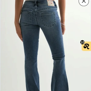 True Religion blå bootcut jeans - ‼️Pris kan diskuteras‼️Säljer assnygga true religion jeans i mörkblå!! De har ljusrosa detaljer på fickorna och inte blå som på de första bilderna. Väldigt lågmidjade!! ”Vintage” aktiga ränder över hela jeansen som tillhör designen 💕 Ägt i några månader