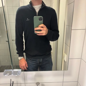 Marinblå GANT halfzip-tröja – strl M - Snygg och stilren zip-tröja från GANT i marinblått med vit kragmarkering som detalj. Klassisk och tidlös – funkar både till vardags och lite mer uppklätt. Fint skick, skulle säga 8,5/10.