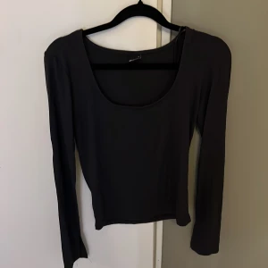 Svart långärmad topp Gina Tricot - Svart långärmad topp från Gina Tricot i storlek S. Modellen har en djup rundad halsringning och är figurnära med stretchigt material som känns skönt mot huden. Perfekt att styla med jeans eller kjol för en clean och enkel look. Köpte för inte så länge sedan och har inte kommit till användning❤️