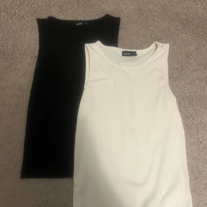 Linnen från LMTD - Två linnen LMTD, en i svart och en i vit. Båda är ärmlösa med rund hals och har en ribbad struktur. Perfekt för dig som gillar enkel och clean stil. En för 20, två för 30