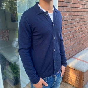 Hackett London Stickad Cardigan - Säljer nu en fet stickad cardigan/overshirt från märket Hackett London i 100% Merino ull | Modell: 178cm & väger 70kg | Storlek: S | Skick: 9/10, som ny, inga defekter | Nypris: 2600kr, vårat är 749kr ~ Hojta gärna till vid fråga eller fundering 💭 