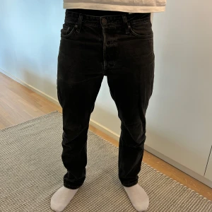 Jack&Jones jeans - Ett par snygga svarta jeans från Jack and Jones. Jeansen är använda med ett litet slitage på baksidan av jeansen (skriv och fråga om bild vid intresse ). Modellen på jeansen är loose / Chris. Nypris ca 600kr.  Hör av dig vid frågor eller funderingar 